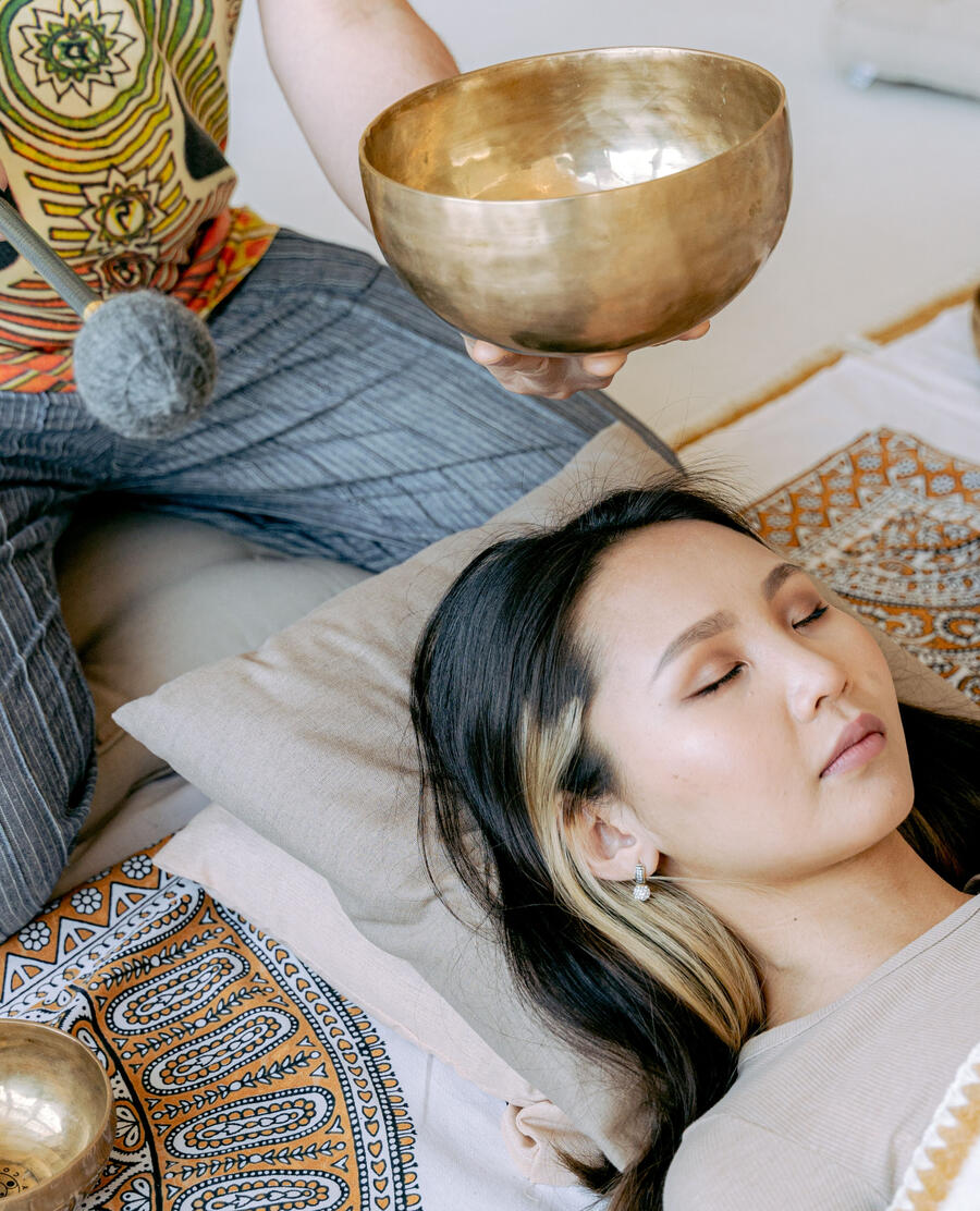 Woman in a sound bath laying down with eyes closed